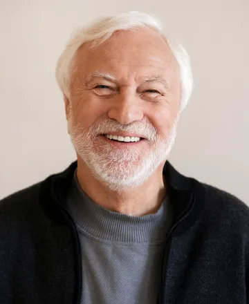 Smiling older man with white hair and a beard