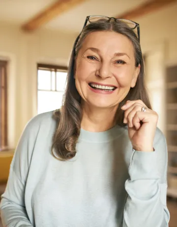 Smiling older woman with glasses resting on her head
