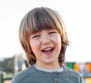 Laughing young boy outdoors