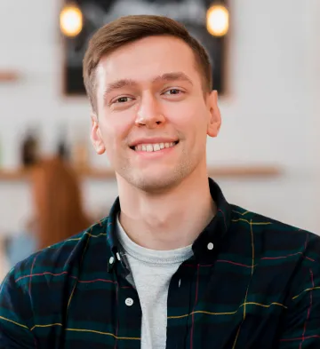Smiling young man in a plaid shirt