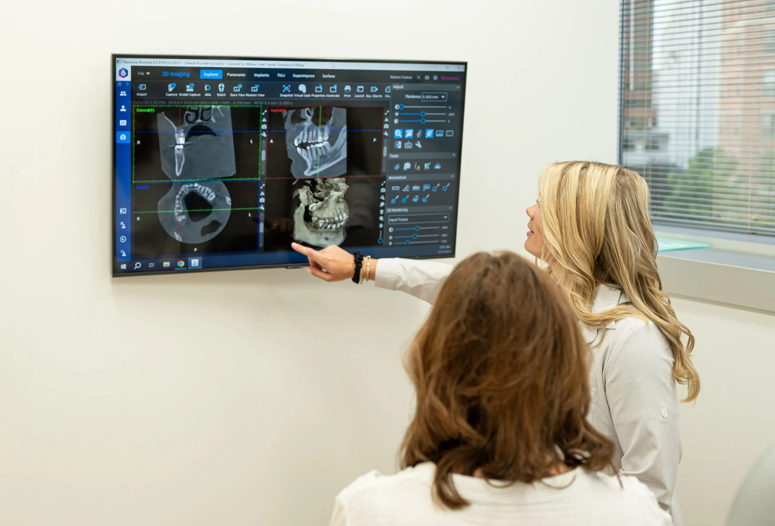 A Stanbrick dentist walking a patient through their 3D imaging on a wall-mounted screen