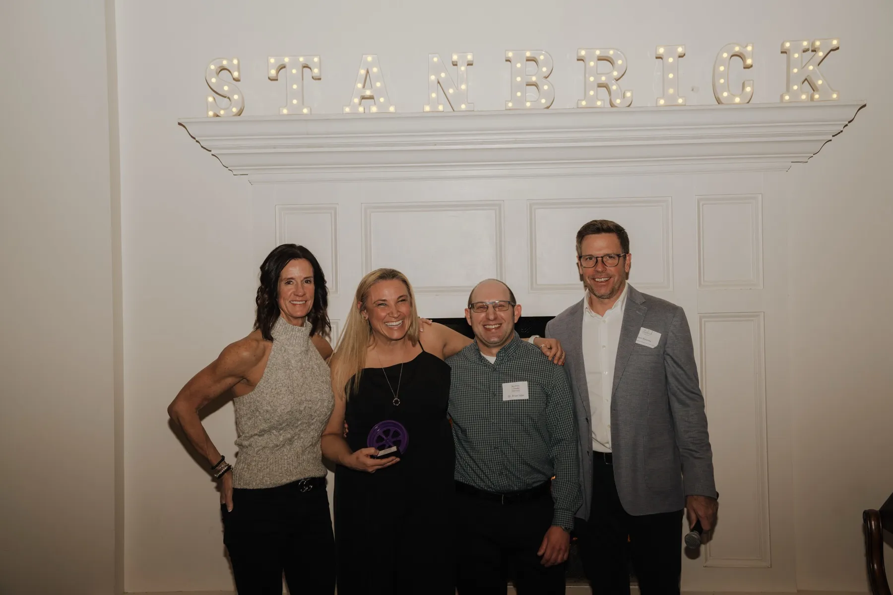 An award winner with colleagues under the Stanbrick marquee lights
