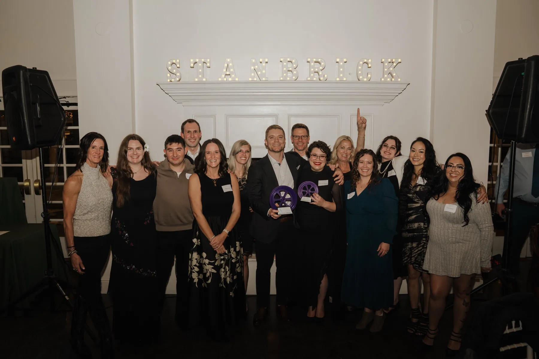 The whole Stanbrick team gathered under the lit marquee sign at the holiday party