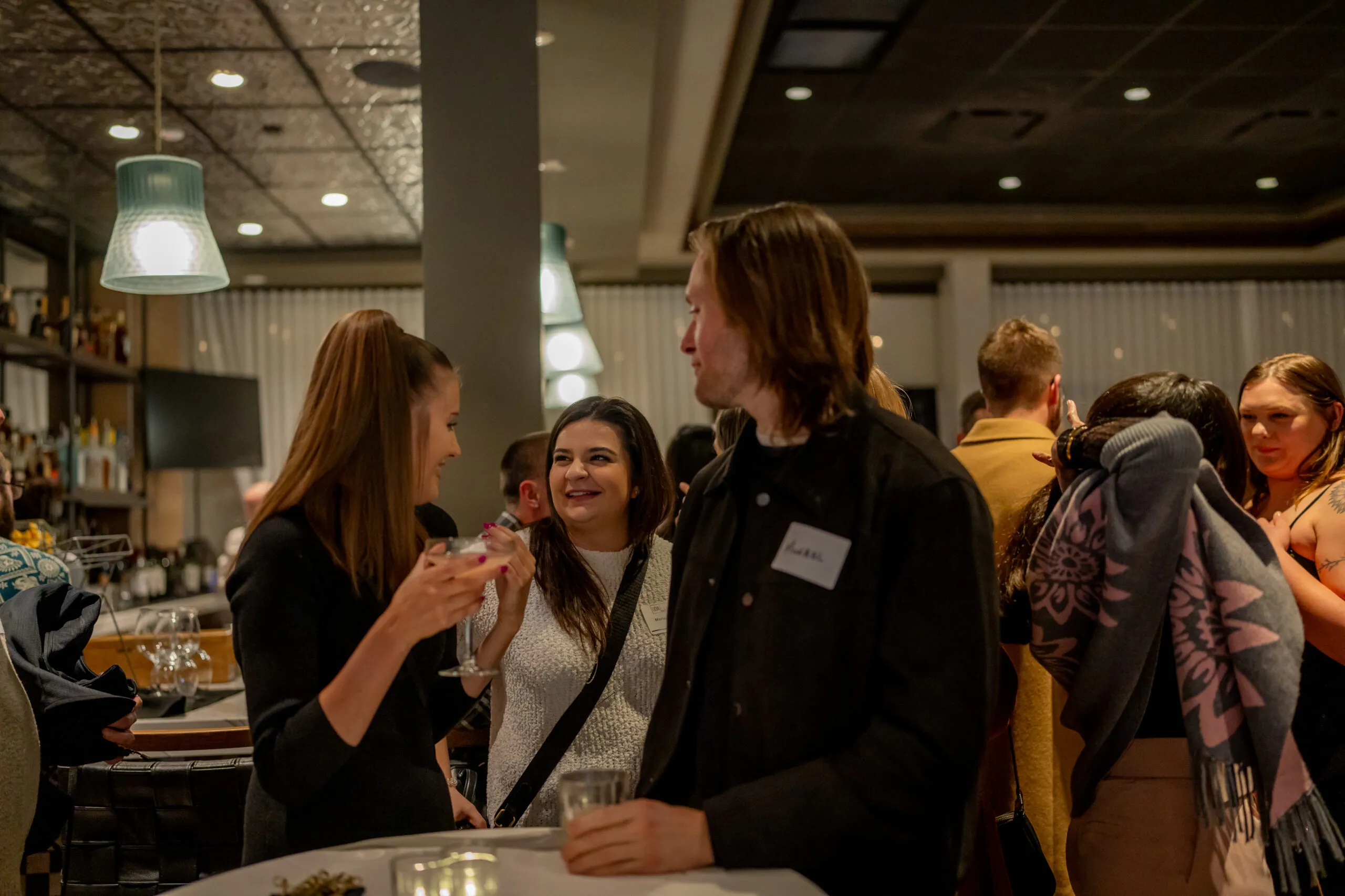 Two teammates laughing together at a company event