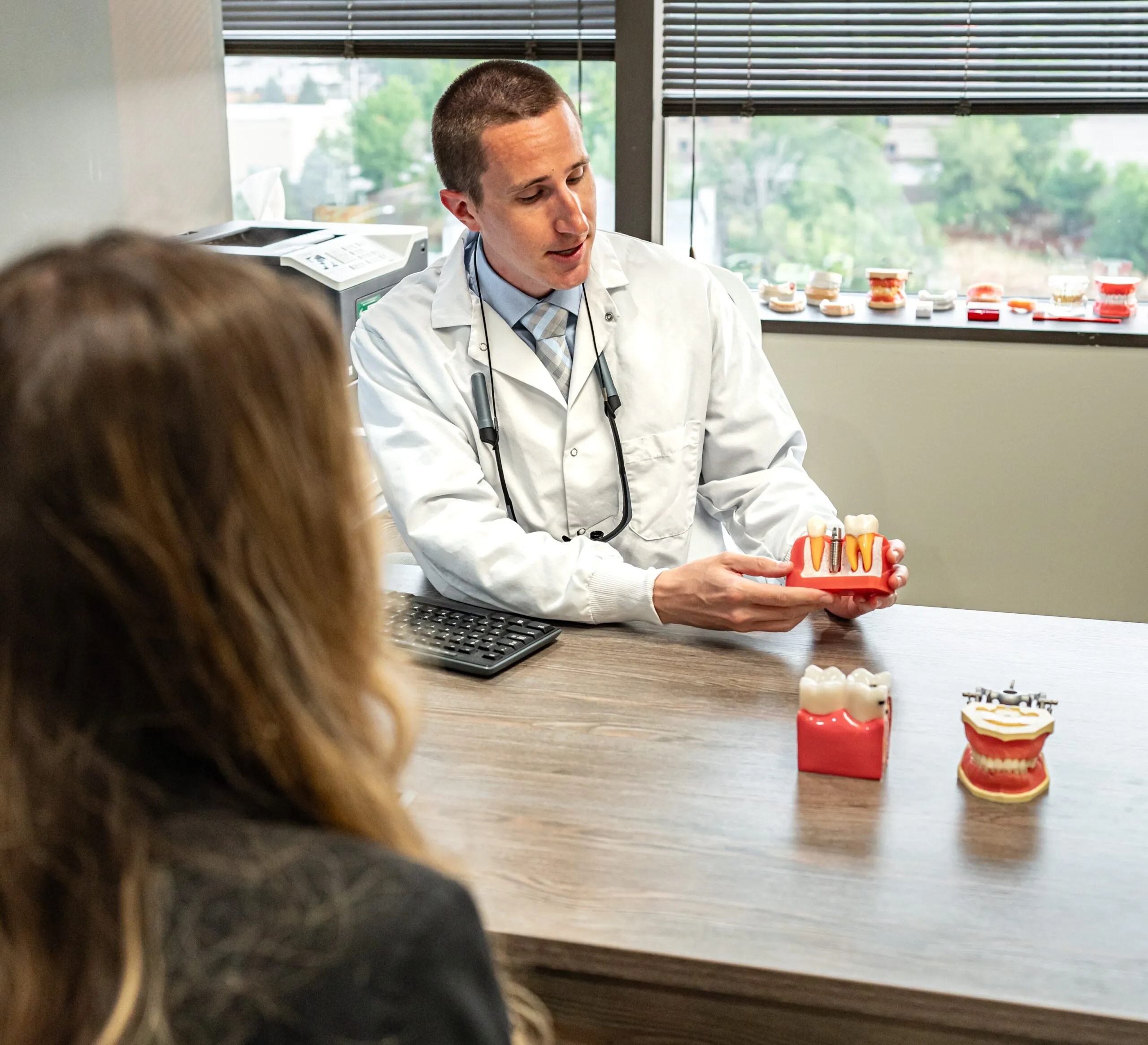 A Stanbrick dentist talking a patient through a dental model across the desk