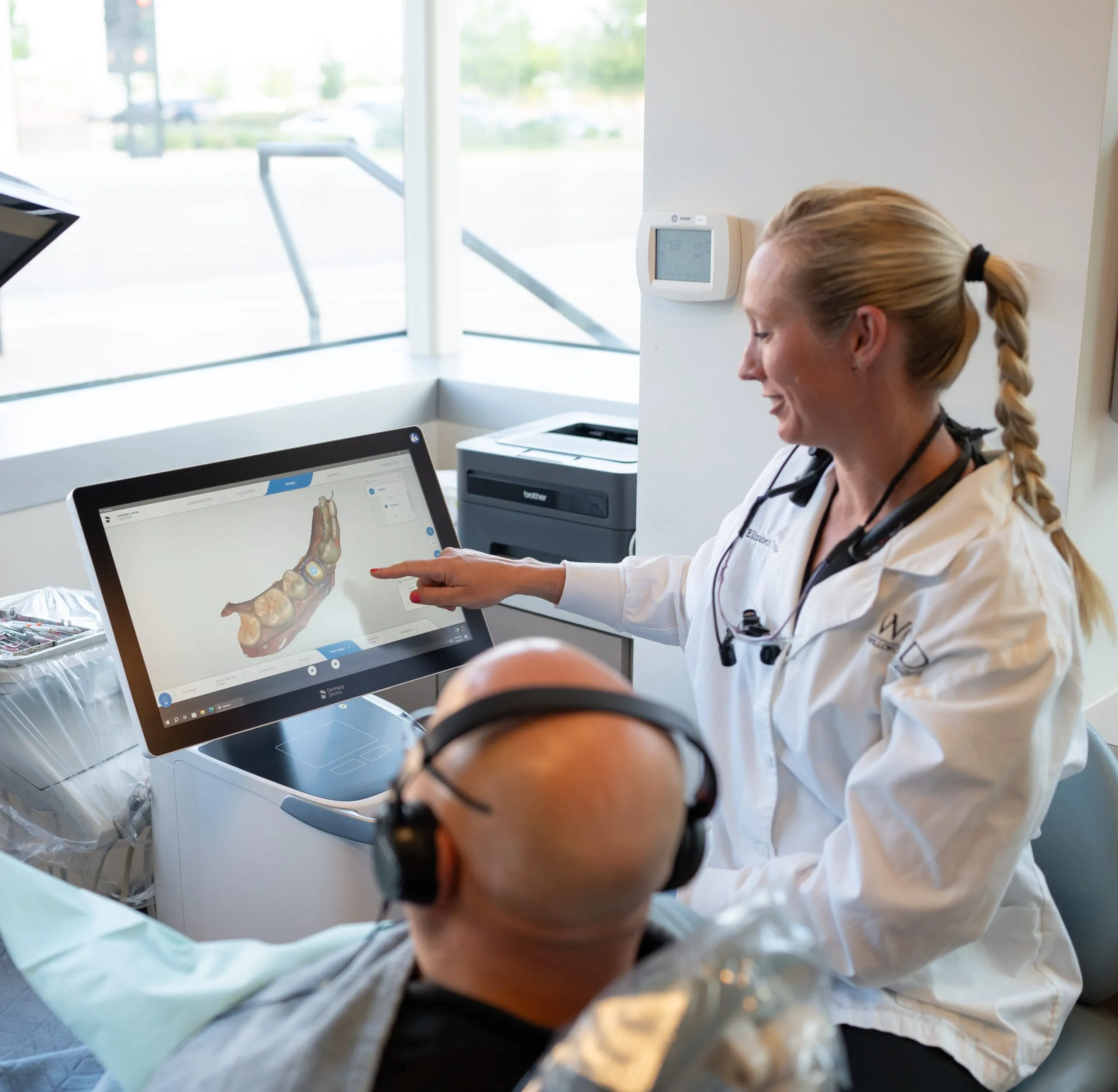 A Stanbrick dentist reviewing a 3D scan on screen with a patient in the chair