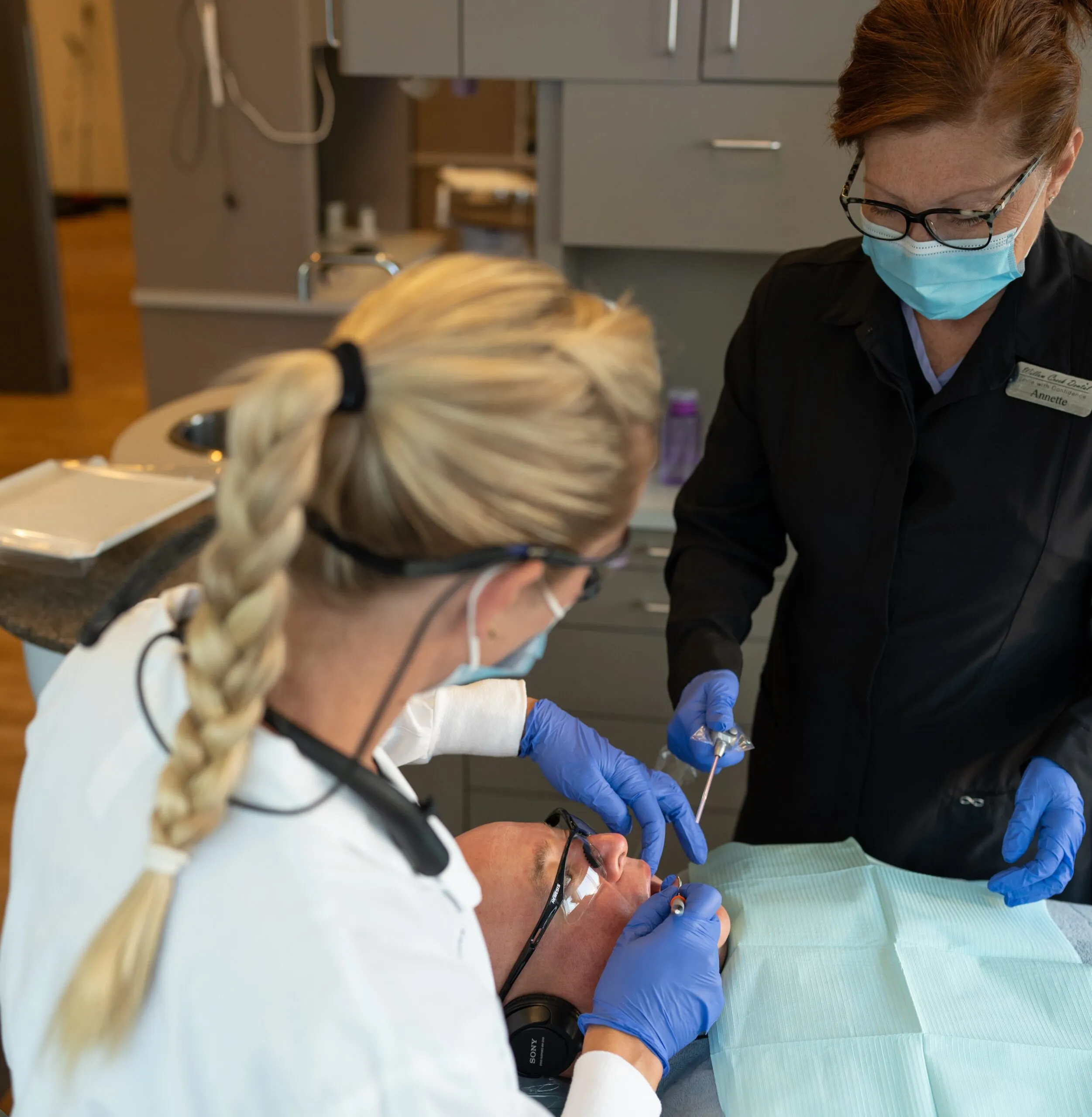 A hygienist providing a re-care visit to keep a patient’s smile healthy
