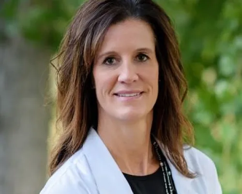 Dr. Mary Blakeley, founder of Willow Creek Dental, photographed outdoors in her white coat